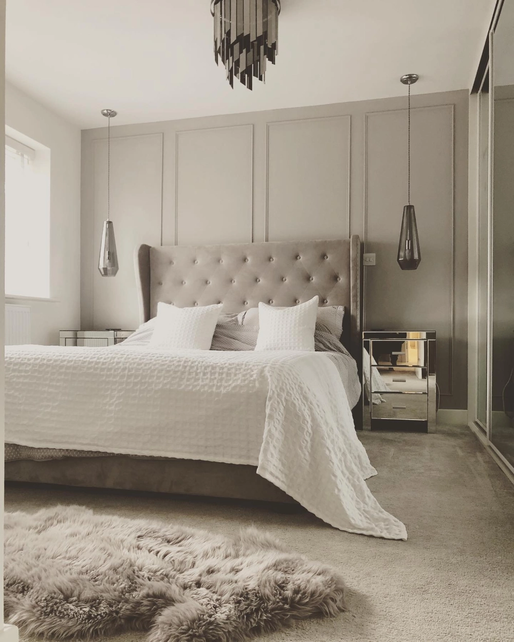 Màu sơn phòng ngủ tông xám trung tính sang trọng kết hợp với vách ốp tường và đèn thả trần hiện đại
