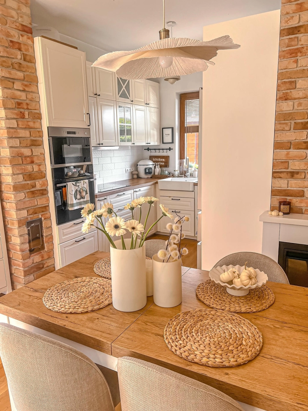 Không gian phòng bếp với thiết kế bếp hiện đại sử dụng tông màu trắng sáng và đảo bếp tiện nghi